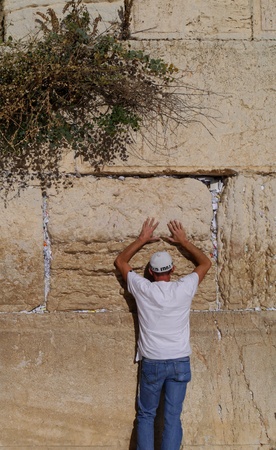 Jerusalem, Israel - October 2011:   A Jewish man prays at the Western Wall, the holiest site of Judaism.   The cracks between the stones are full of the traditional "notes to God."のeditorial素材
