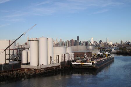New York, USA, October 2009 - industrial area in Brooklyn, with barges and Manhattan skyline in the...