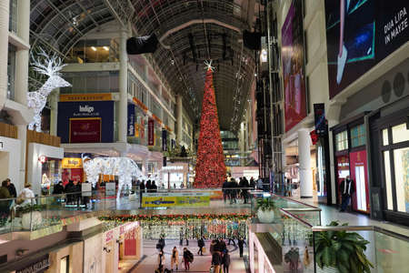 Toronto, Canada - December 20, 2021:  Toronto's Eaton Center is a multi-level indoor mall, with bright Christmas decorations and shoppers wearing face masks due to the pandemicのeditorial素材