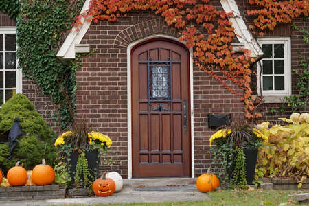 front door of house with Halloween decorations and pumpkinsの写真素材