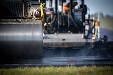 A roller compacting asphalt on a road