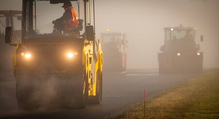 A roller compacting asphalt on a road
