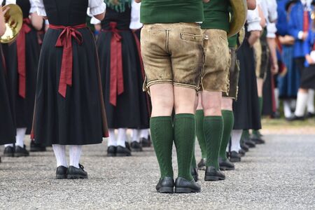 Men with leather pants and women in dirndl dress - traditional attire