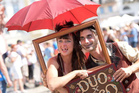 Two artists at Linz pavement spectacle with an umbrella and a window frameのeditorial素材