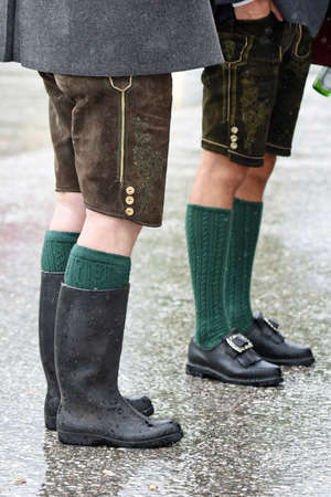 A man with leather pants and rubber boots in the rain in the Salzkammergut -のeditorial素材