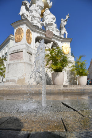 Fountain in front of the plague column on the town square of the spa town of Baden near Vienna, Lower Austria, Austriaの写真素材
