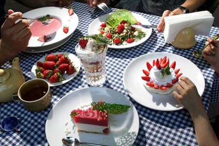 family at the table eating strawberry dessertsの写真素材