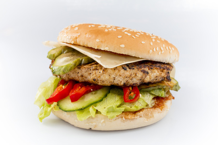 tasty burger with cheese and vegetables on a white backgroundの写真素材