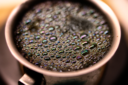 Macro shot of brewed coffee in a round cup sparkles with bubblesの写真素材