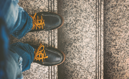 Vintage Fashion of a Man Wearing Blue Jeans and Leather Shoes on the Staircaseの写真素材