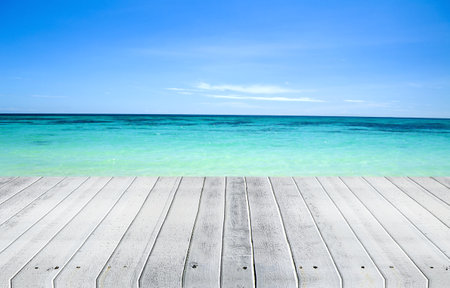 Wooden deck on tropical beach with blue sea and sky background.の写真素材