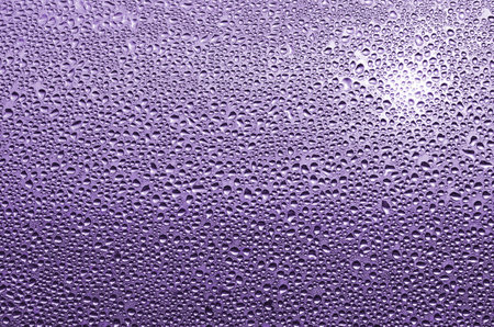 Water drops on a purple glass. Abstract background and texture for design.の写真素材