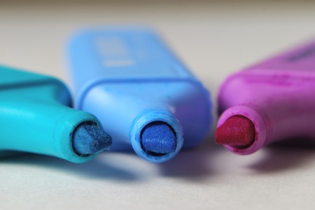 Markers in different colors lying on a deskの写真素材