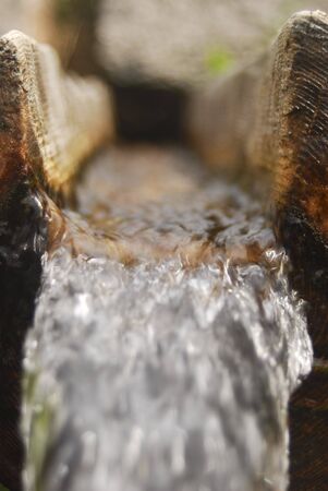 Refreshing cold water in a wooden spring.の写真素材