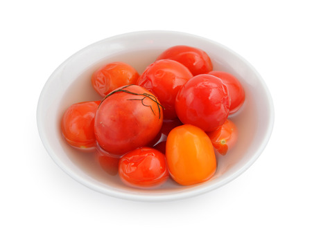 Marinaded tomatoes in a white plate. Isolated on white background.の写真素材