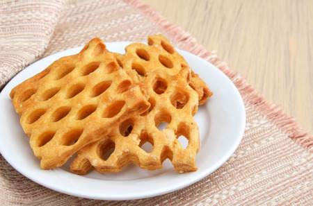 Cake with holes on white plate.の写真素材