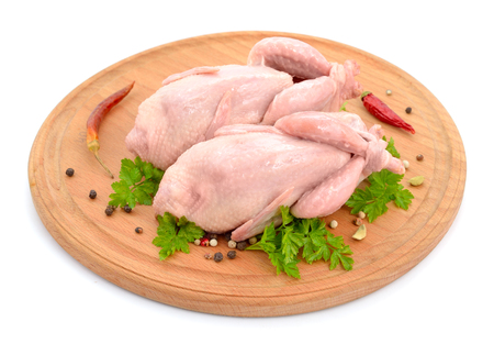 Quail meat on the round board. Isolated on white background.の写真素材