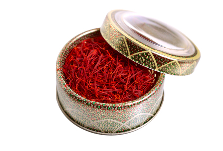 Delicate saffron threads, plucked from crocus flowers and dried. In the ethnic box. Isolated on white background.の写真素材