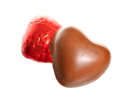 Red Foil wrapped chocolate hearts isolated on white backgroundの写真素材