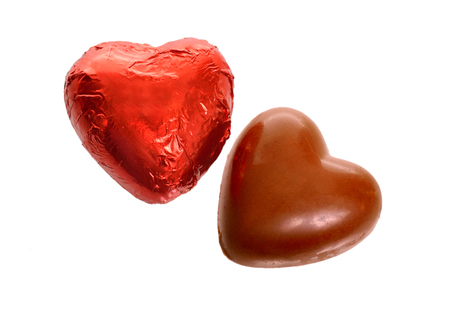 Red Foil wrapped chocolate hearts isolated on white background.の写真素材