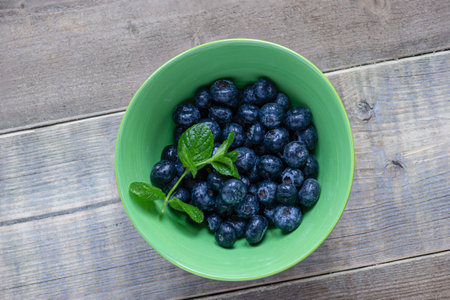 Bowl of blueberries with mint leaves photographed from above.の写真素材