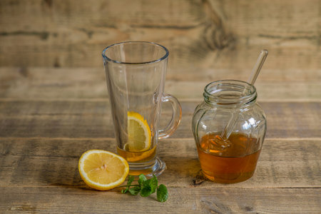 Honey and lemon on a wooden tableready to be mixed with water for a soothing drink.の写真素材
