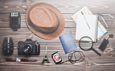 The concept of travel. Geographical map, notebook, hat, equipment of the photographer on a wooden table. Thrust for a trip. Top view.Flat lay.の写真素材