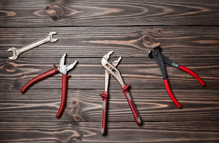 Nippers, wrench keys, pliers on a wooden table.の写真素材
