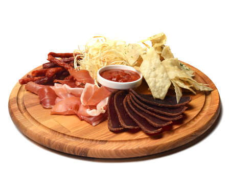 Snack to beer on a wooden board. Basturma, dried meat, dried squid, chips isolated on white background.の写真素材