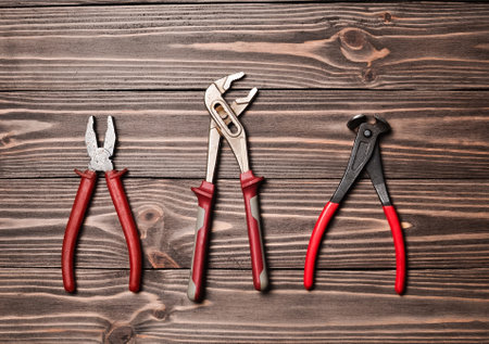 Nippers, wrench, pliers on a wooden table.の写真素材