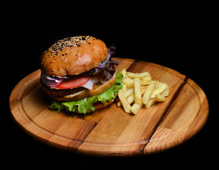 Burger with French fries on a wooden board. Fast food.の写真素材