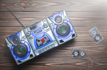 Vintage tape recorder with speakers and audio cassettes on a wooden table. Top view. Flat lay.の写真素材