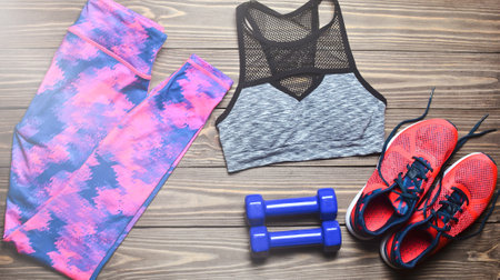 The concept of a sport lifestyle. Dumbbells, sportswear, dyeing on the wooden floor. Top view.Flat lay.の写真素材