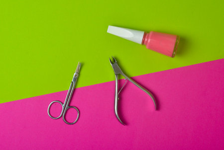 Manicure scissors, nail polish, nail clippers, on a pink green neon background. Trend of minimalism.の写真素材