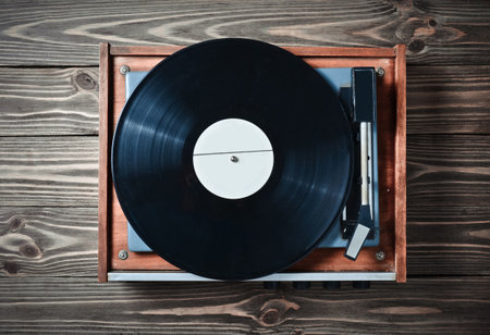 Vinyl player with plates on a wooden table. Entertainment 70s. Listen to music. Top view.