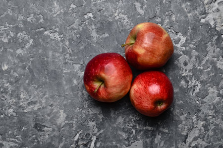 Red ripe apples on a concrete table. Fresh fruits. Loft and rustic style. Top viewの写真素材