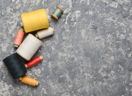 A group of multicolored skeins of thread on a gray concrete background. The concept of needlework. Made hand sewing clothes.の写真素材