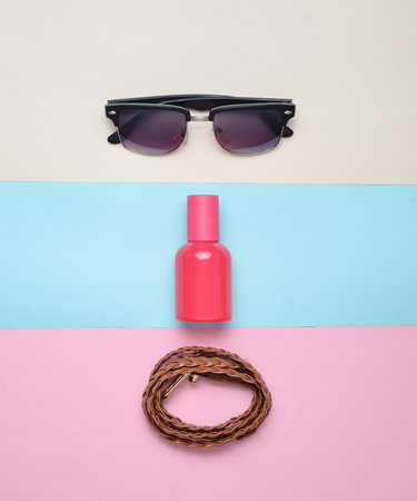 Women's trendy accessories on a multicolored pastel background. Glasses, perfume, leather belt. Top view. Minimalism.の写真素材