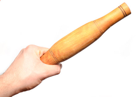 A man's hand holds a wooden rolling pin isolated on white background. Kitchen tools for cooking.