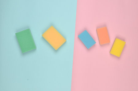Many multi-colored sponges for cleaning on a pink blue pastel background. Trend of minimalism. Top view.の写真素材