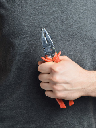 Pliers in the man's hand.