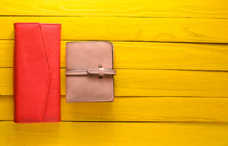Two women's purse on a yellow wooden background. Trend accessories. Copy space. Top view.の写真素材