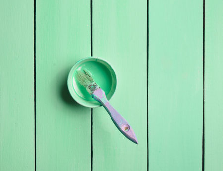 Trendy pastel colors. A paintbrush and a paint jar on a turquoise wooden background. Top view. Flat lay. Copy space.の写真素材