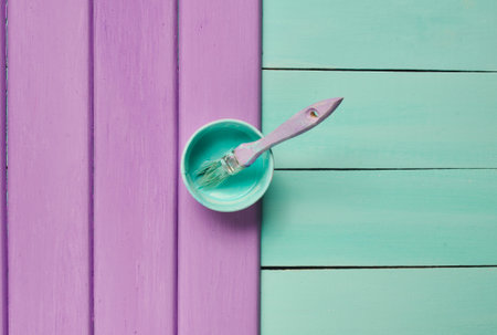 Trendy pastel colors. A paintbrush and a paint jar on a purple turquoise wooden background. Top view. Flat lay. Copy space.の写真素材