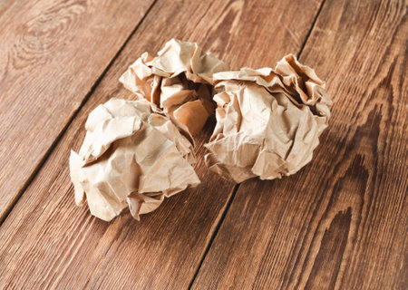 Balls of crumpled old paper on a wooden table. The concept of inappropriate, spent ideas.の写真素材