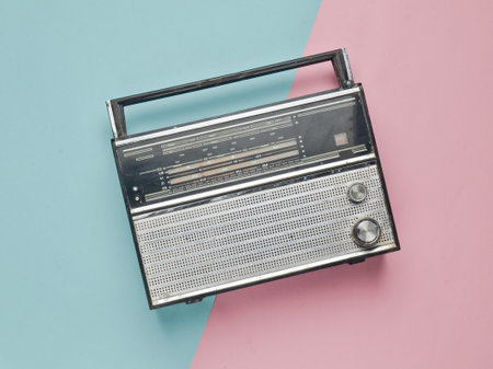 Retro radio receiver on a pink blue pastel background. Media technology 60s. Top view.の写真素材