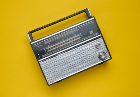 Top view of a retro radio receiver on a yellow background. Culture of the 70s. Top view.の写真素材