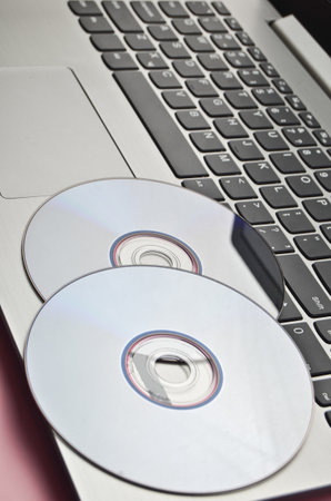 CDs on the laptop. Modern technologies.
