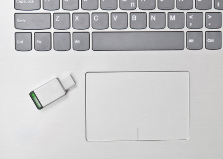 USB flash drive on the laptop keyboard. Modern media technologies.