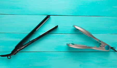 Two hair iron on a blue wooden background. Hair care. Top view.の写真素材